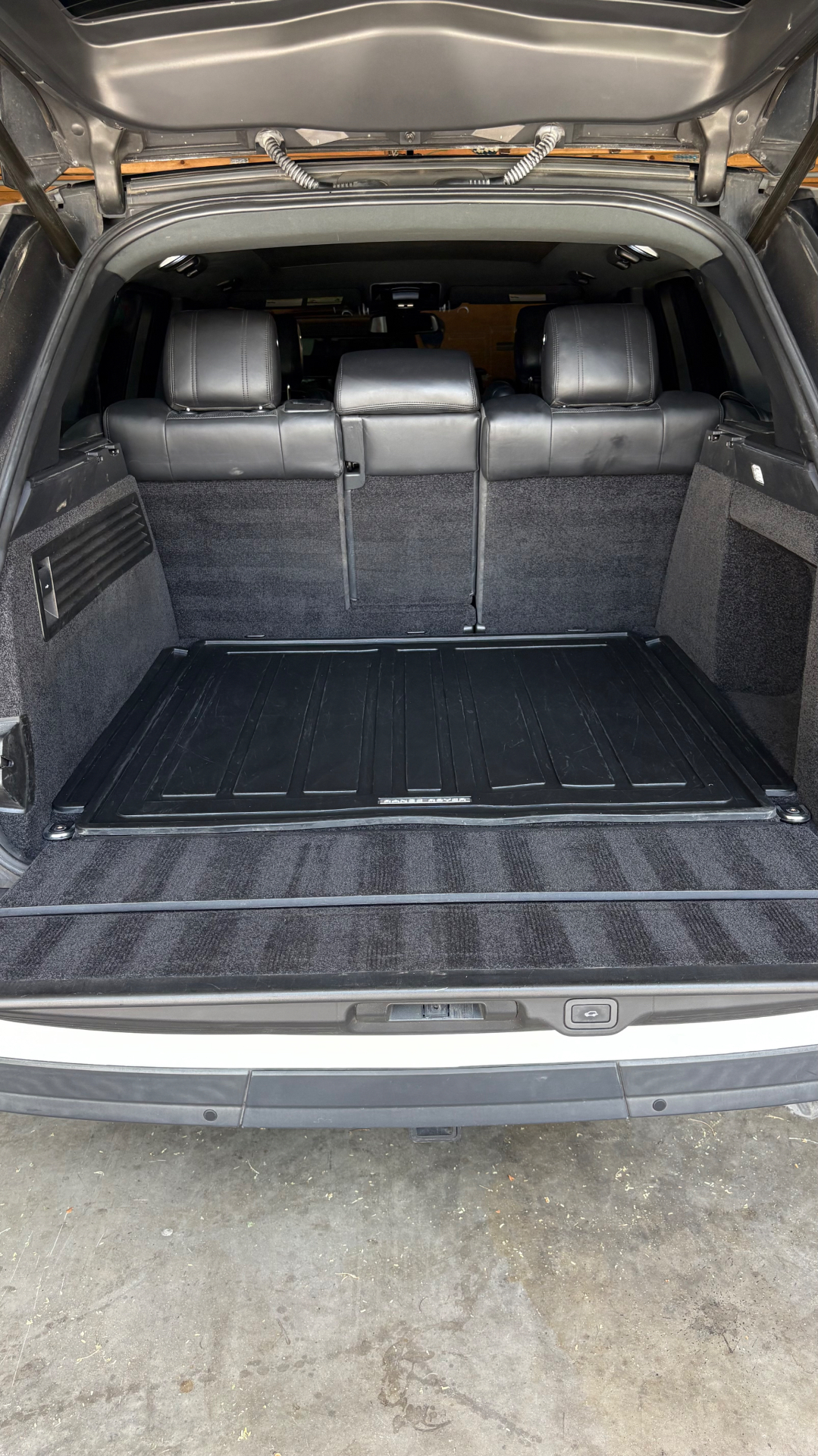 SUV cargo area vacuumed and detailed with liner cleaned